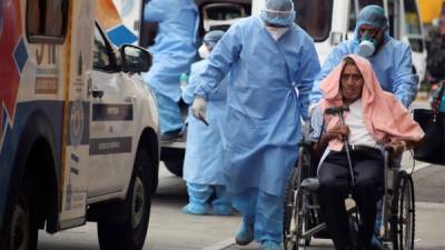 Personal de salud traslada a un paciente con probabilidades de haber contraido la covid-19 al hospital San Felipe, donde son atendidos los casos positivos en Tegucigalpa, Honduras.