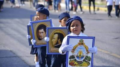 Niños hondureños cargan cuadros de símbolos y próceres patrios, entre ellos, el Escudo Nacional; Francisco Morazán, José Cecilio del Valle, entre otros.