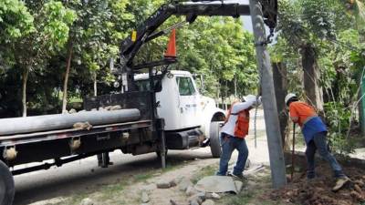 Empleados de una empresa privada instalan los postes.