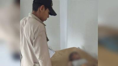 Un bombero observa el cuerpo sin vida de Bryan Pineda en la camilla de un centro hospitalario.