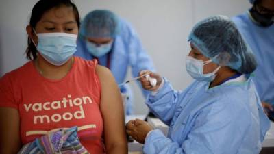Una joven recibe su primer dosis de vacuna contra la covid-19 en un centro de salud en San Salvador (El Salvador).