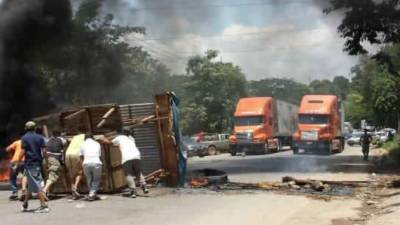 Varias personas mueven un vehículo para ponerle en medio de la carretera.