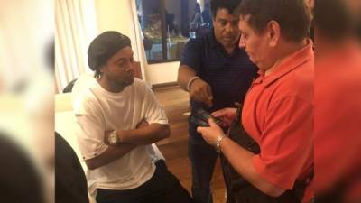 Fotografía cedida por la Fiscalía paraguaya que muestra el momento del operativo de allanamiento por parte de las autoridades a la habitación en la que se hospeda el astro del fútbol brasileño Ronaldinho Gaúcho (i) este miércoles, en el hotel Yacht y Golf Club de la ciudad de Lambaré (Paraguay).