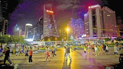 La gente baila en la noche en la Plaza del Retrato de Deng Xiaoping en el distrito de Luohu en Shenzhen.
