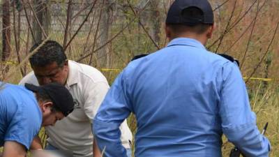 Personal de Medicina Forense y de la Policía Nacional de Honduras en el lugar del levantamiento del cadáver de un estudiante capitalino.