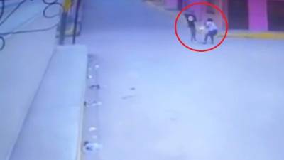 Momento exacto en que el hombre le quita la cartera que cargaba la mujer.