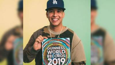 Daddy Yankee mientras posa con el libro de los récords Guinness que contiene sus reconocimientos. Foto Guinness World Records (GWR).