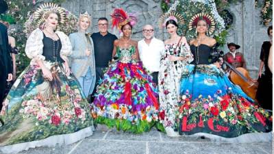 Domenico Dolce y Stefano Gabbana posan con modelos al cierre de una de sus pasarelas.