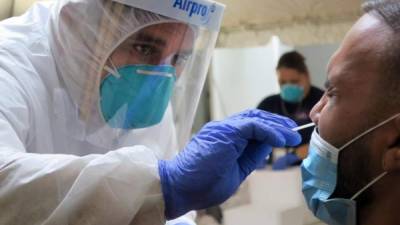 Un técnico de laboratorio inserta un hisopo en la nariz de un residente para la prueba del coronavirus el 24 de julio de 2020 en San Juan (Puerto Rico).