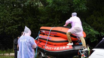 Los miembros del equipo Bluesky preparan balsas de rescate antes de dirigirse a Zhengzhou, una ciudad del centro de China afectada por las inundaciones. Foto AFP