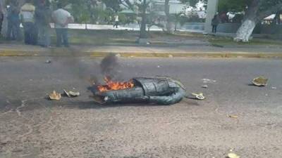Luego de derribar la estatuta de Chávez, los manifestantes la prendieron en fuego.