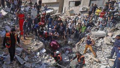 Los paramédicos palestinos buscan sobrevivientes bajo los escombros de un edificio destruido en la ciudad de Gaza. Foto AFP
