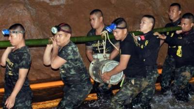 Fotografía cedida por el Real Ejército de Tailandia, de varios miembros de un equipo de rescate mientras intentaban drenar el agua de la cueva. EFE