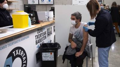 Un trabajador sanitario vacuna a un hombre contra el covid-19 durante una campaña de vacunación. Foto AFP