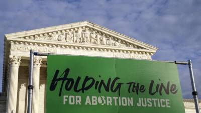 Un cartel de Holding the Line se ve durante la Marcha de Mujeres “Mantenga la línea por la justicia del aborto” en la Corte Suprema de los Estados Unidos.