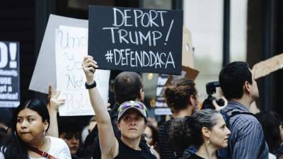 Personas sostienen pancartas durante una protesta en contra de la decisión del presidente Donald Trump. EFE/Archivo