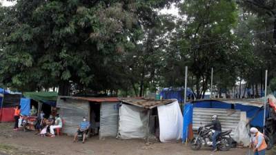 Personas descansan hoy junto a casas improvisadas tras evacuar sus hogares en la colonia la Betania, debido a la crecida del río Choluteca tras el paso de Iota, en Tegucigalpa (Honduras).