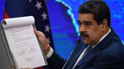 El presidente venezolano Nicolás Maduro muestra un documento firmado por representantes de su Gobierno y la oposición durante las negociaciones en México. Foto AFP