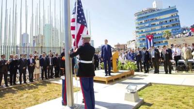 El Secretario de Estado de EE.UU., John Kerry, junto a otros dignatarios iza la bandera de EE.UU. por primera vez en la reabierta embajada de ese país.