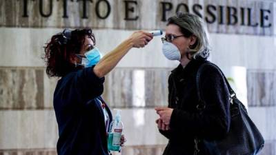 Una mujer (R) tiene su temperatura controlada en la entrada del hospital IFO Regina Elena y San Gallicano durante la pandemia de coronavirus en Roma, Italia, el 17 de abril de 2020.
