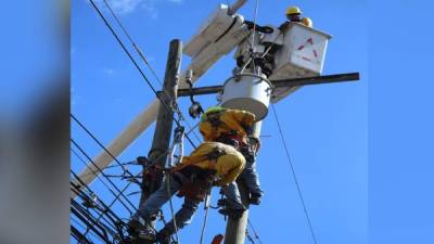 Servicio. Empleados reparan el tendido eléctrico en San Pedro Sula. archivo.