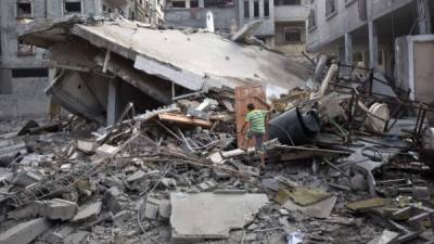 Niños palestinos buscan sus pertenencias en las ruinas de sus hogares luego de ser atacados por aviones israelíes.