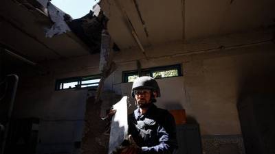 Un miembro de un equipo de remoción de minas del Servicio Estatal de Emergencia de Ucrania lleva una parte de un misil luego del bombardeo ruso.