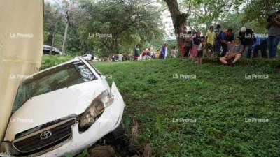 El taxi quedó contra el muro de una casa. Al fondo uno de los pasajeros era atendido.