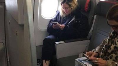 Aunque viajó en clase económica, la estrella sí se permitió el lujo de tener espacio extra para sus piernas. Foto redes.