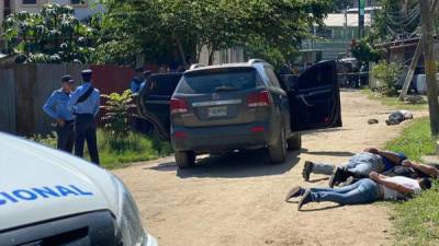Imagen donde aparecen los tres detenidos y al fondo el hombre herido, quien quedó boca abajo y cerca de un vehículo.