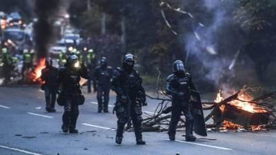 La policía antidisturbios avanza hacia los manifestantes que bloquean una carretera durante una nueva protesta antigubernamental en Medellín. Foto AFP