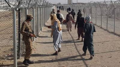Un soldado paquistaní habla con un ciudadano afgano varado mientras regresan a el puesto fronterizo. Foto AFP