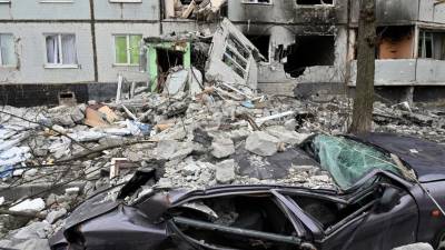 Automóvil destruido frente a un edificio dañado en la parte norte de Kharkiv.