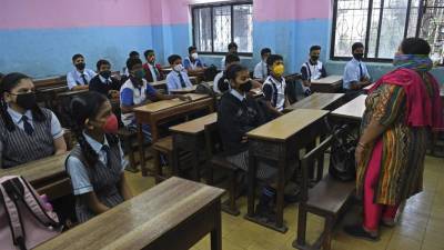 Los estudiantes asisten a su clase en una escuela en Mumbai luego de que se reabrieran las escuelas que estaban cerradas como medida preventiva para frenar la propagación del coronavirus.