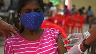 Una mujer es inoculada con una dosis de la vacuna contra el coronavirus en una universidad en Chennai. Foto AFP