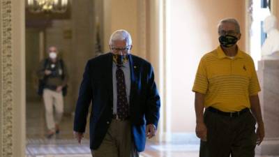 En esta foto de archivo, el senador y presidente del Comité de Presupuesto Mike Enzi usa una máscara protectora mientras camina por el Capitolio de los Estados Unidos. Foto AFP