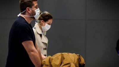 Una pareja protegida con tapabocas, como medida de precaución contra la propagación del virus COVID-19, fue registrada este lunes en el Aeropuerto Internacional de Sao Paulo (Brasil).