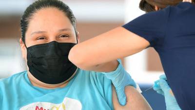 Cecilia Sánchez recibe su primera dosis de la vacuna Pfizer en una clínica móvil organizada por McDonald’s y el departamento de Salud Pública de California.