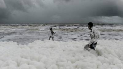 Muchas familias ignoran la advertencia y se lanzan a la playa a nadar en la espuma.