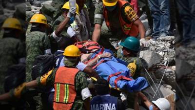 Hasta los momentos las muertes ascienden a 225, según informan fuentes oficiales.// Foto de rescatistas ayudando a una víctima del sismo del 19 de septiembre en Ciudad de México- AFP.
