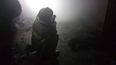 Bomberos trabajando dentro de la vivienda para controlar las llamas.