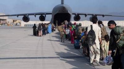 Pilotos y capitanes de la Fuerza Aérea de EE.UU. cargando pasajeros en apoyo de la evacuación de Afganistán. Foto AFP