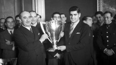 El alcalde de Madrid, Alberto Alcocerv (i), hace entrega de la Copa de Campeones de Liga 1940-1941, al capitán del Atlético de Aviación, José Mesa, en una imagen de archivo.