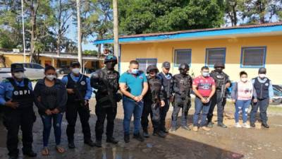 Los cuatro detenidos siendo custodiados por agentes de la DPI en La Ceiba.