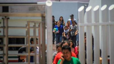 Decenas de migrantes, la mayoría con niños, retornan a territorio mexicano por la garita del chaparral, en la ciudad de Tijuana, del estado de Baja California (México).