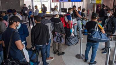Un grupo de ciudadanos y residentes de Honduras varados en Estados Unidos por el coronavirus esperan en fila para subir a un avión este sábado en el Aeropuerto Internacional de Fort Lauderdale, a 40 kilómetros al norte de Miami, Florida (EEUU).