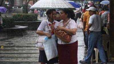 Mujeres se protegen de la lluvia. Foto: José Cantarero.