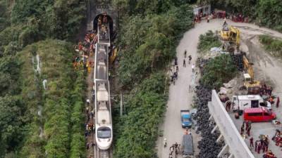 Una vista aérea muestra a los rescatistas en el lugar donde el tren descarriló dentro de un túnel. Foto AFP