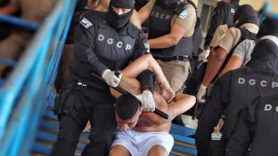 Miembros de la Mara Salvatrucha y Barrio 18 siendo llevados por las fuerzas de seguridad a un patio de la prisión en Ciudad Barrios, El Salvador.