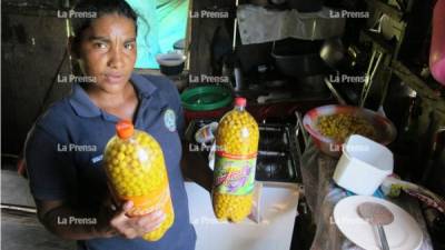 Una misquita de Yahurabila, Puerto Lempira, muestra las botellas llenas de nances, que son la provisión de su familia.